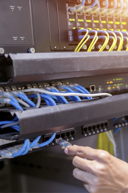 Conectando un cable de red en un rack de cableado estructurado.